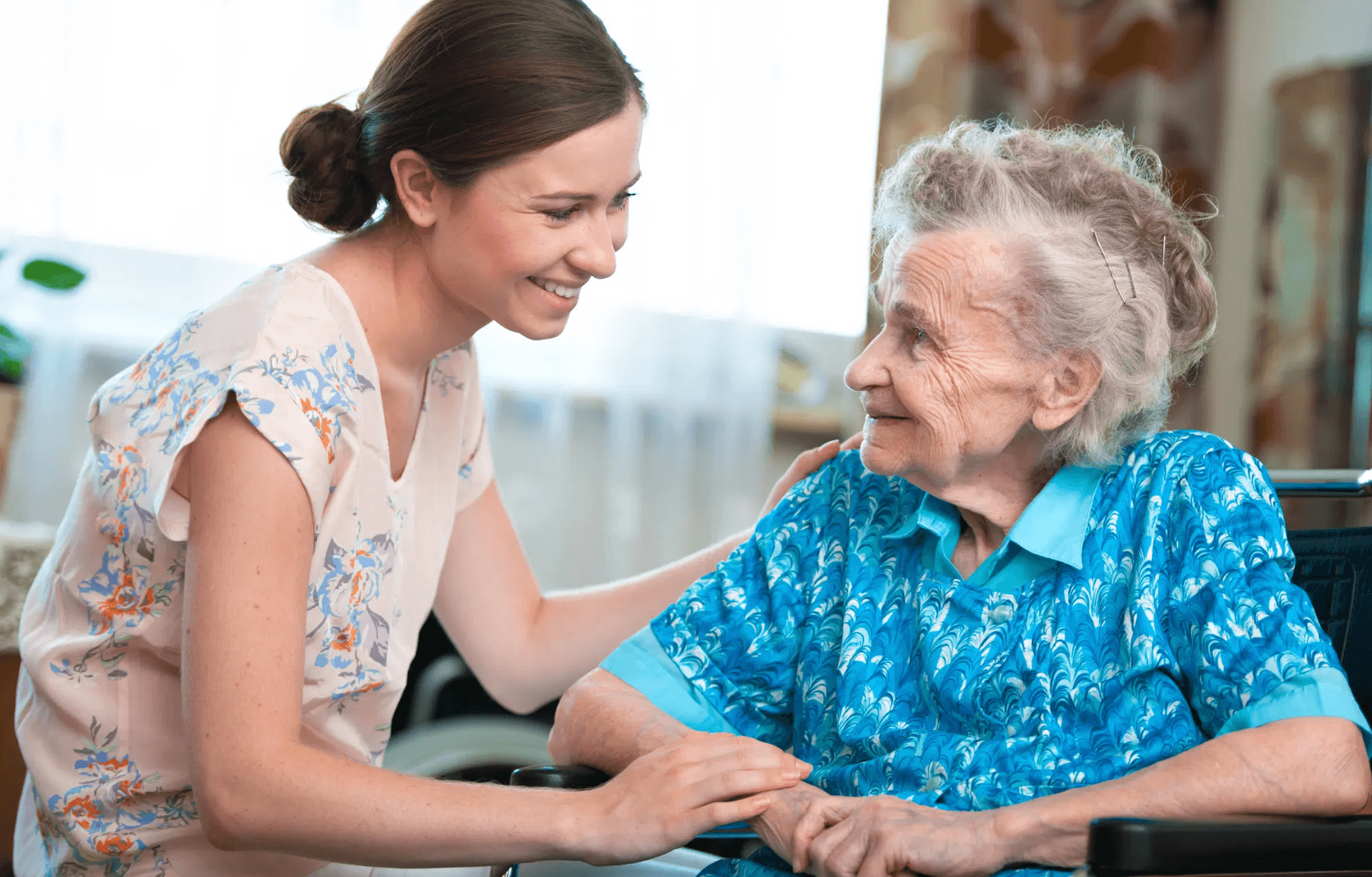 A caregiver spending time with a senior in a warm, natural setting